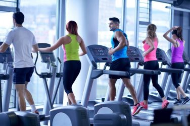 Group of people running on treadmills